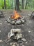 Campfire and wood pile in an outdoorsy, forest setting. Camping scene.