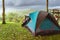 Camping activities in rain-filled holiday. Tent on campsite by the hill in rainy day. Tent wet after rain. Water droplets on the
