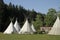 Camping area surrounded by teepee tents and greenery under the sunlight