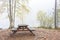 Camping bench and table in misty forest
