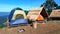 The camping blue/Green and orange tent on wooden litter with dry leaves roof and blue sky, mountain and tree