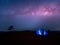 Camping. Blue tent glows under a night sky with milky way