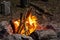 Camping Campfire. Burning branches in a hearth enclosed by stone