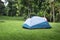 Camping Campsite and Tent on Green Grass Under The Trees Tropical Forest, Field Campground for Vacation Outdoors Leisure Activity