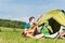 Camping couple playing guitar by tent countryside