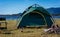 Camping green tent near lake