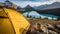 Camping with holding cup in yellow tent open with Peyto Lake in Icefields Parkway at Canada