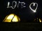 Camping Love long exposure light painting with flashlights. Creating love text and symbol with long exposure near illuminated tent
