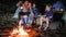 Camping, mum with son and daddy with kerosene lamp in hands photographed on gadget near fire, parents and kid