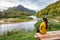 Camping nature woman sitting at picnic table enjoying view of wilderness river in Quebec and autumn foliage forest