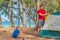 Camping people outdoor lifestyle tourists putting up setting up their green grey campsite in summer forest near lazur