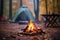 Camping site with fire lit in fire pit in Autumn woods with beautiful Fall foliage colors. Autumn seasonal concept.