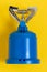 Camping and survival concept. Close-up of a blue Camping stove or gas cooker on a yellow background. Macro photograph of gas