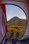 Camping with tent on the Alps. View from tent interior at sunrise, body part. Adventure and exploration, outdoor activity.