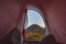 Camping with tent on the Alps. View from tent interior at sunrise, body part. Adventure and exploration, outdoor activity.