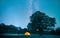 Camping with tent in forest at night with starry sky