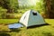 Camping tent on grass over beautiful forest