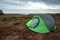 Camping tent green in the background of nature and lake. The concept of travel, tourism, camping