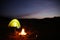 Camping tent near bonfire at night