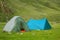 Camping and tent under the pine forest in sunset at north of ThailandTwo simple tourist tents stand in a meadow. In the background