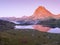 Camping tents on Lake Gentau at night with Mount Midi d`Ossau reflected on the lake.