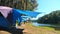 Camping tents standing near river in forest with pine trees. Summer vacation