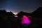 Camping under starry sky and Milky Way arc at high altitude on the italian french Alps. Glowing tent in the foreground. Adventure