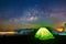 Camping under the stars with illuminated tent, Milky Way galaxy, Long exposure photograph, with grain.Image contain certain grain