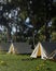 A campsite in a beautiful green forrest with big trees. Tents in camping area