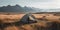 Campsite off the grid. Hiking and camping in the wilderness. Tent in the plains with a mountain range in the distance.