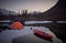 Campsite with orange tent and canoe on a lake