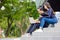 On campus, a gorgeous couple in casual attire uses a laptop while sitting on the outdoor stairwell