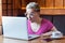 Can not believe! Side view portrait of emotional shocked young businesswoman in pink t-shirt is sitting in cafe, reading news and