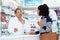 Can you describe the pain you feel in your throat. Shot of a pharmacist assisting a young woman in a chemist.