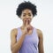 Can you keep a secret. Studio shot of an attractive young woman posing with her finger on her lips against a grey