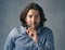 Can you keep a secret. Studio shot of a man posing with his finger on his lips against a grey background.