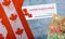 Canada doubles value of coronavirus stimulus economic response plan Canadian flags canadian dollar bills on background