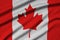 Canada flag is depicted on a sports cloth fabric with many folds. Sport team banner
