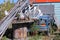 Canada. Old table in the outside covered with caribou and moose antlers, pieces of junk and a car in the background with a