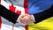 Canada and Ukraine handshake international friendship relations, flag background