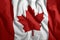 The Canadian flag flies in the wind. Colorful national flag of Canada. Patriotism, patriotic symbol