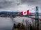 Canadian flag waving at Prospect Point in Stanley Park with the Lions Gate Bridge in the background in Vancouver, BC.