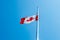 The canadian national flag on a flagpole on a blue sky at Ottawa, Canada