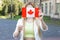 Canadian woman cover your face. Young girl raised the flag of Canada