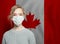 Canadian woman wearing a face mask with national flag of Canada. Flu epidemic and virus protection concept