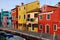 Canal with boats and homes of many colors and clothes to dry in Burano in Venice in Italy