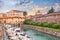 canal with boats and walls of the old fortress in Livorno, Tuscany, Italy