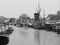 Canal with boats and windmill at a cloudy day in Leiden