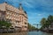 Canal with brick building, bascule bridge, restaurant and blue sky in Amsterdam.