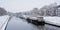 Canal in the city of Ghent with living boats on a winter day with snow